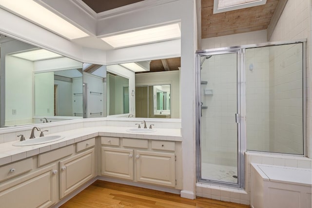 bathroom with vanity, hardwood / wood-style floors, and a shower with door