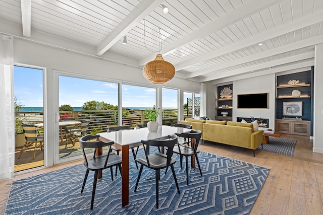 dining space with wood-type flooring, beam ceiling, plenty of natural light, and built in features