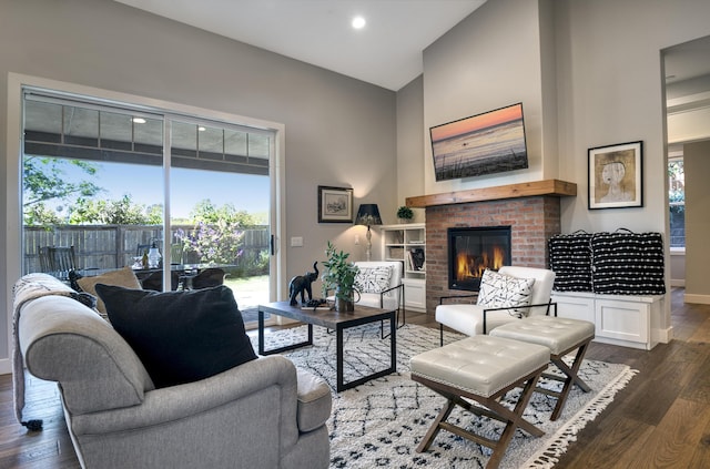 living area featuring high vaulted ceiling, a brick fireplace, baseboards, and wood finished floors