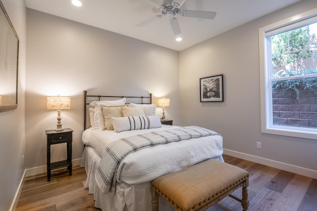 bedroom featuring a ceiling fan, baseboards, wood finished floors, and recessed lighting