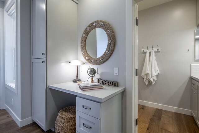 bathroom with wood finished floors, vanity, and baseboards