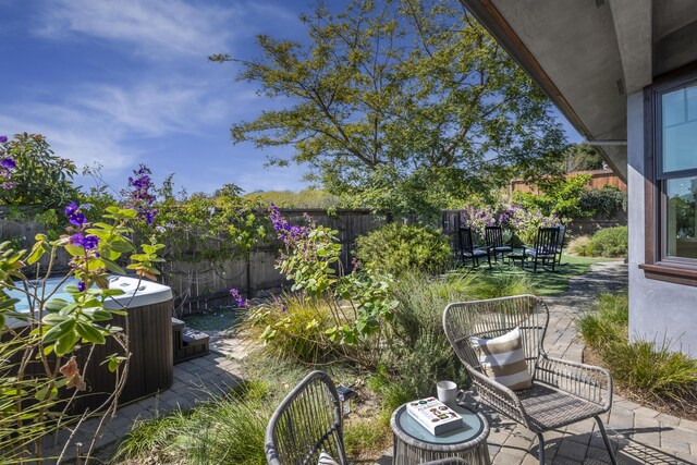 view of patio / terrace featuring a fenced backyard, a hot tub, and central AC unit