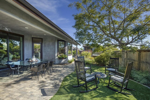 view of patio with an outdoor fire pit, fence, and outdoor dining area