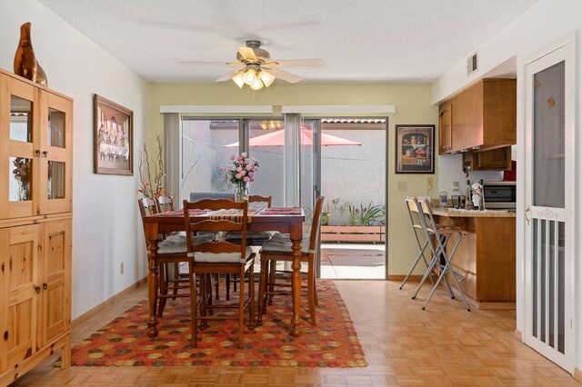 dining space featuring ceiling fan, a wealth of natural light, and a textured ceiling