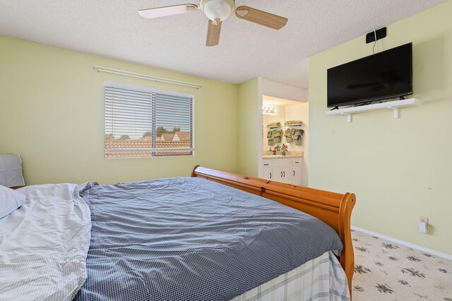 carpeted bedroom featuring ceiling fan, ensuite bathroom, and a textured ceiling