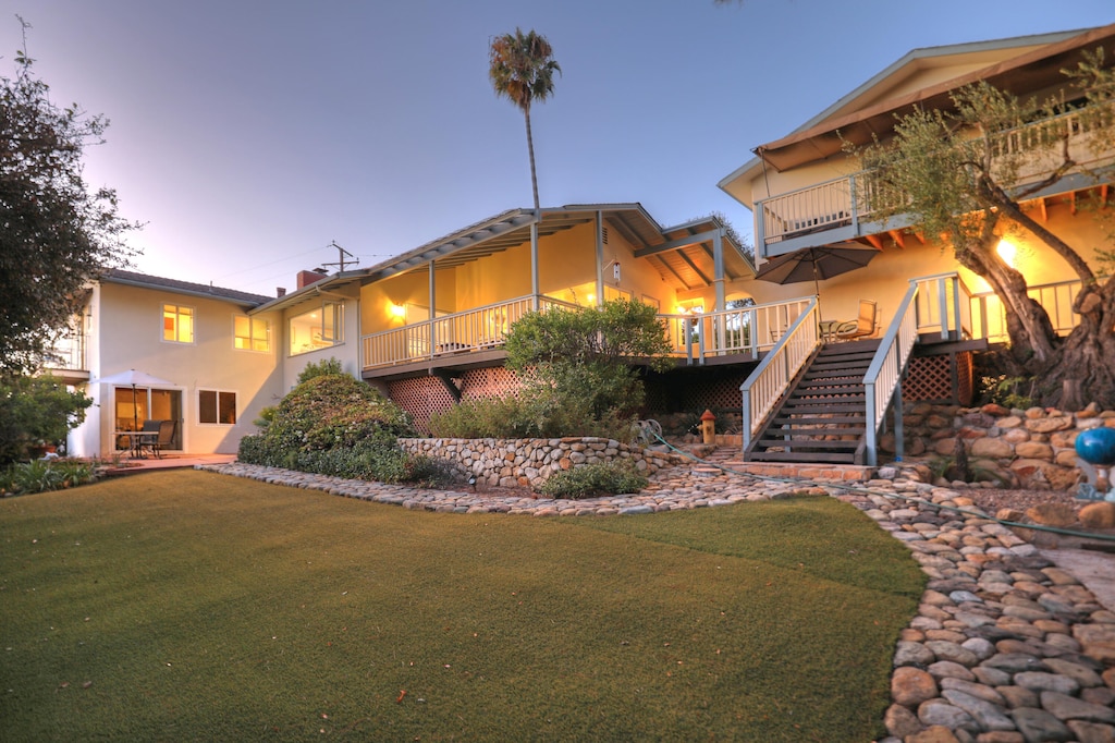 view of front of home with a lawn and a balcony