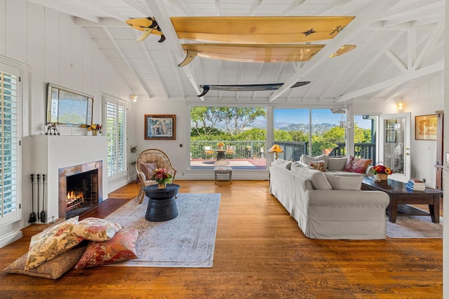 3050 Serena Rd, Santa Barbara, CA 93105 - living room with vaulted ceiling with beams, a warm lit fireplace, and wood finished floors