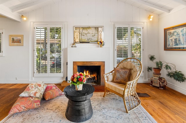 3050 Serena Rd, Santa Barbara, CA 93105 - living area with baseboards, lofted ceiling with beams, a lit fireplace, and wood finished floors
