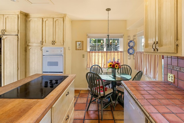 3050 Serena Rd, Santa Barbara, CA 93105 - kitchen with tile countertops, tasteful backsplash, baseboards, a chandelier, and white appliances