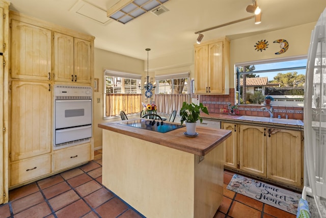 3050 Serena Rd, Santa Barbara, CA 93105 - kitchen with light brown cabinets, black electric cooktop, wooden counters, a warming drawer, and white oven