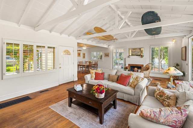 3050 Serena Rd, Santa Barbara, CA 93105 - living room with lofted ceiling with beams, a lit fireplace, wood finished floors, and visible vents