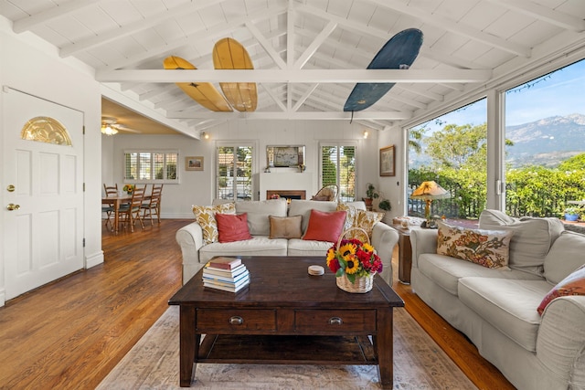 3050 Serena Rd, Santa Barbara, CA 93105 - living area with a warm lit fireplace, lofted ceiling with beams, a ceiling fan, wood finished floors, and wood ceiling