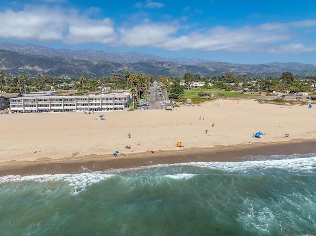 drone / aerial view featuring a water and mountain view and a view of the beach