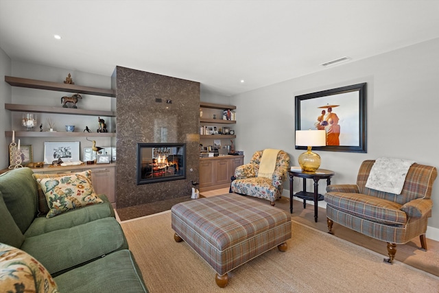 living room featuring light hardwood / wood-style flooring and a tile fireplace