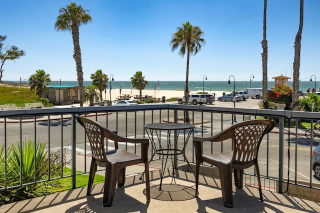 balcony with a water view and a beach view