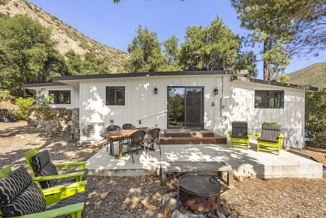 rear view of house featuring ac unit, a patio area, a deck with mountain view, and a fire pit