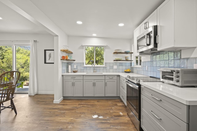 kitchen featuring appliances with stainless steel finishes, a healthy amount of sunlight, and dark hardwood / wood-style floors