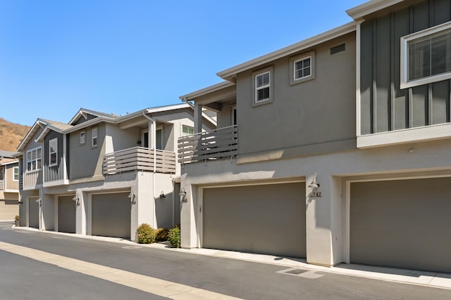 townhome / multi-family property featuring a balcony and a garage