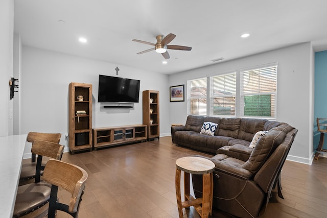 living room featuring ceiling fan and dark hardwood / wood-style flooring