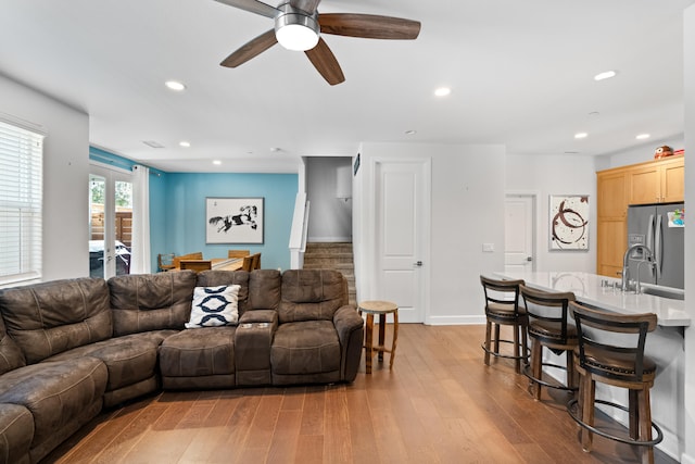 living room with light wood-type flooring and ceiling fan