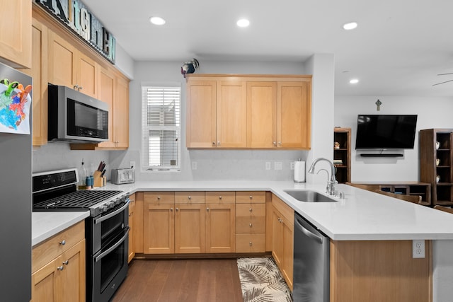 kitchen featuring light brown cabinets, sink, kitchen peninsula, appliances with stainless steel finishes, and dark hardwood / wood-style floors