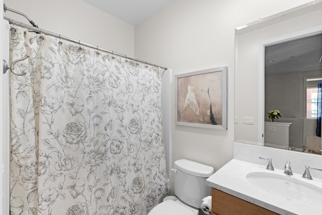 bathroom featuring walk in shower, vanity, and toilet