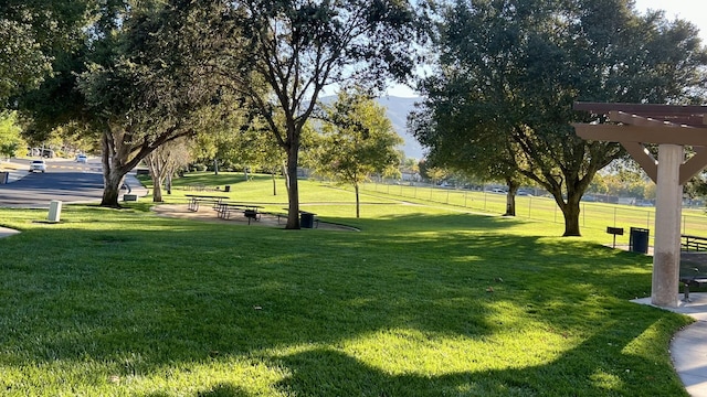 view of property's community with a pergola and a yard