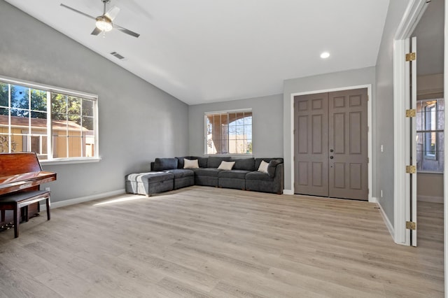 living room with visible vents, baseboards, lofted ceiling, ceiling fan, and light wood-style floors