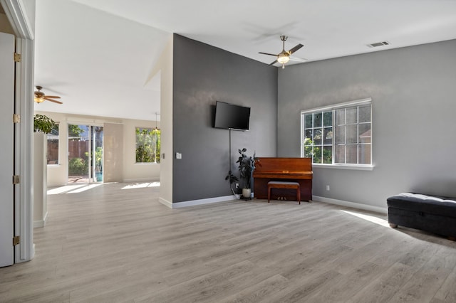 interior space featuring visible vents, baseboards, light wood-style flooring, and a ceiling fan