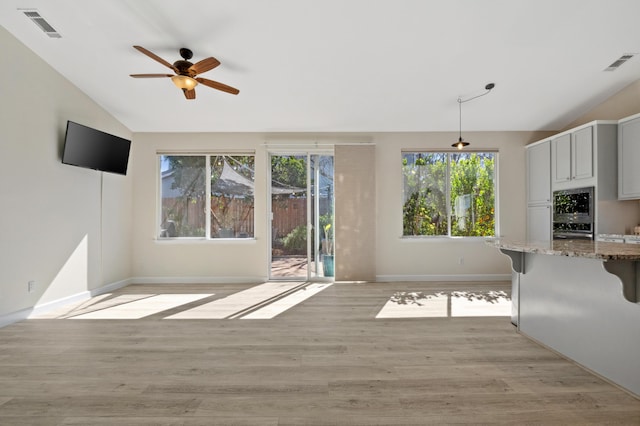 unfurnished living room with lofted ceiling, light wood-style floors, and visible vents