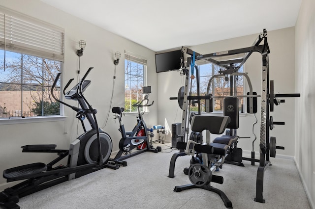 workout room with baseboards and carpet flooring