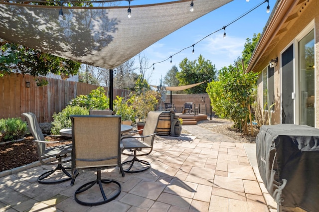 view of patio featuring a grill, outdoor dining area, and a fenced backyard