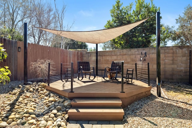 wooden terrace featuring a fenced backyard