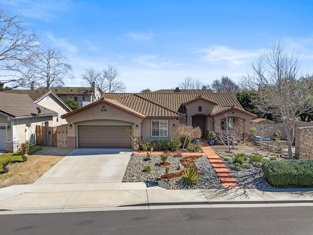 mediterranean / spanish home featuring fence, an attached garage, stucco siding, concrete driveway, and a tiled roof