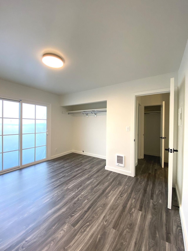 unfurnished bedroom with a closet and dark hardwood / wood-style floors