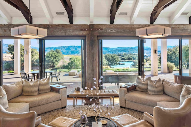 living room featuring lofted ceiling with beams, a mountain view, and a healthy amount of sunlight