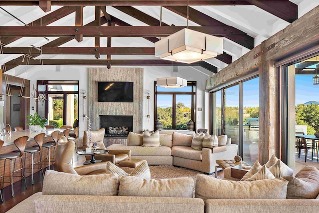 living room featuring high vaulted ceiling, wood-type flooring, beam ceiling, and a high end fireplace