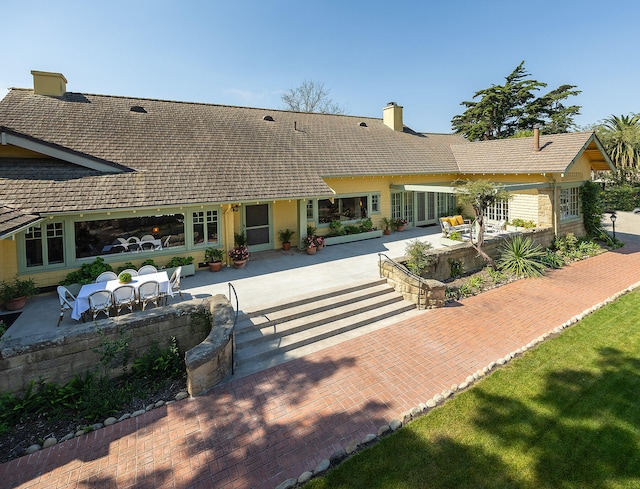 rear view of house featuring outdoor lounge area, a patio, and a lawn