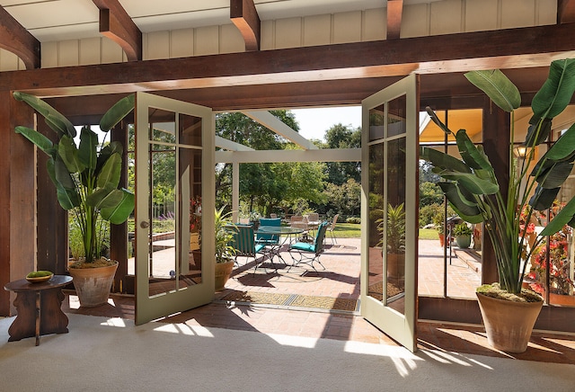 entryway featuring beamed ceiling and carpet flooring