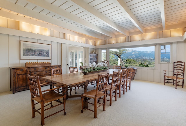 carpeted dining area with beam ceiling and a mountain view