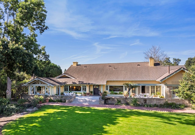 rear view of property with a patio area and a lawn