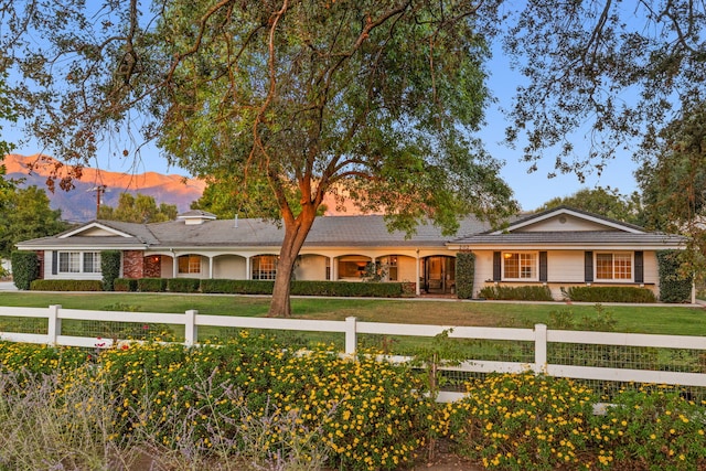 ranch-style home featuring a front lawn and a mountain view