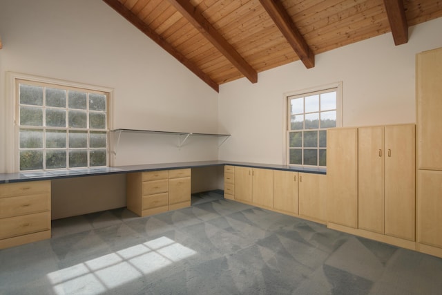 unfurnished office featuring built in desk, beam ceiling, wooden ceiling, and light colored carpet