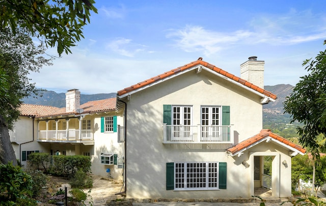 rear view of house with a mountain view and a balcony