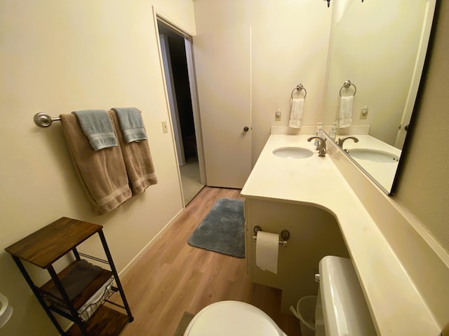 bathroom featuring toilet, vanity, and hardwood / wood-style flooring