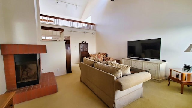 living room with carpet floors, rail lighting, high vaulted ceiling, and a multi sided fireplace