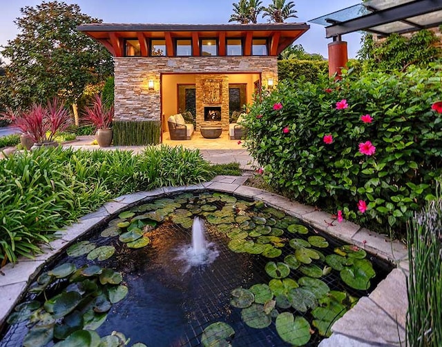 rear view of property featuring an outdoor fireplace