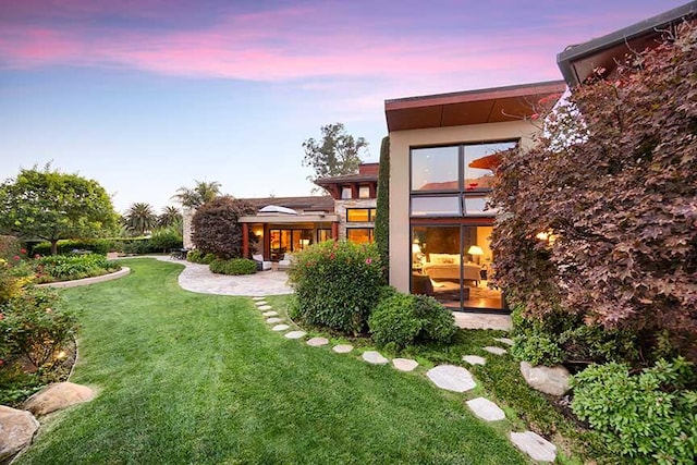 yard at dusk with a patio area