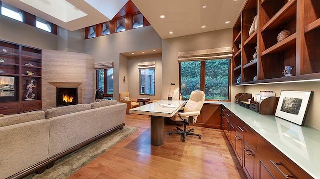 434 Crocker Sperry Dr, Montecito, CA 93108 - home office with recessed lighting, light wood-style floors, built in desk, and a warm lit fireplace