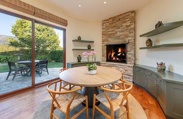 dining space with light hardwood / wood-style floors and an outdoor stone fireplace